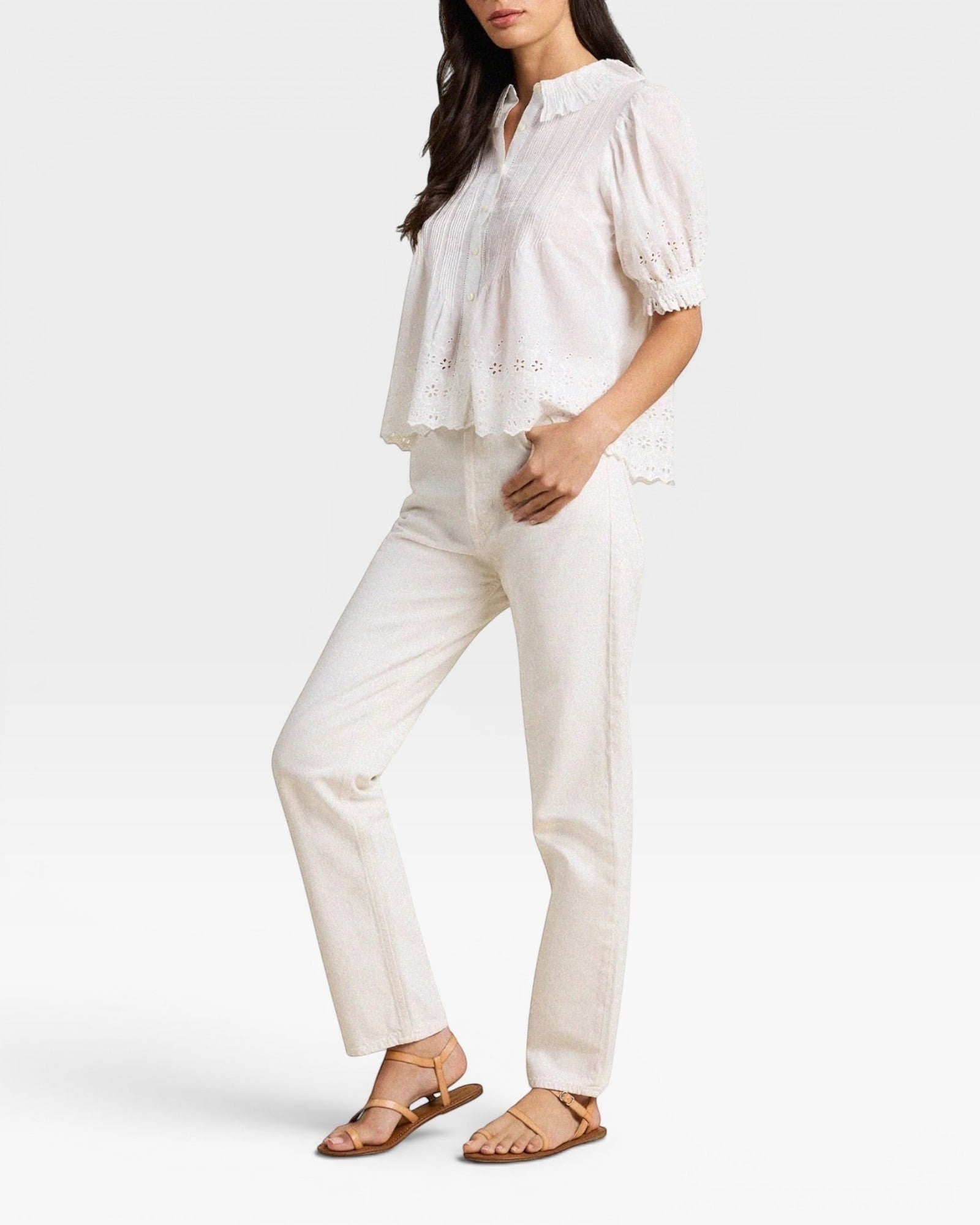 Woman wearing a white blouse and pants on a white background