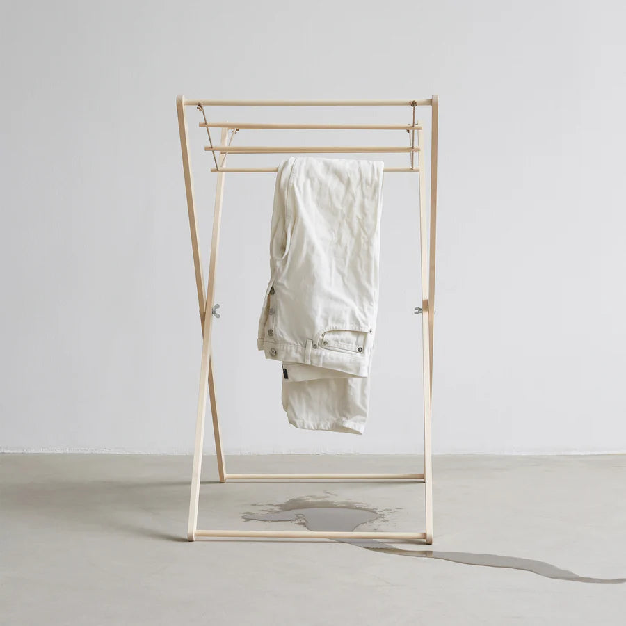 Gold clothing rack with a white garment on a plain background
