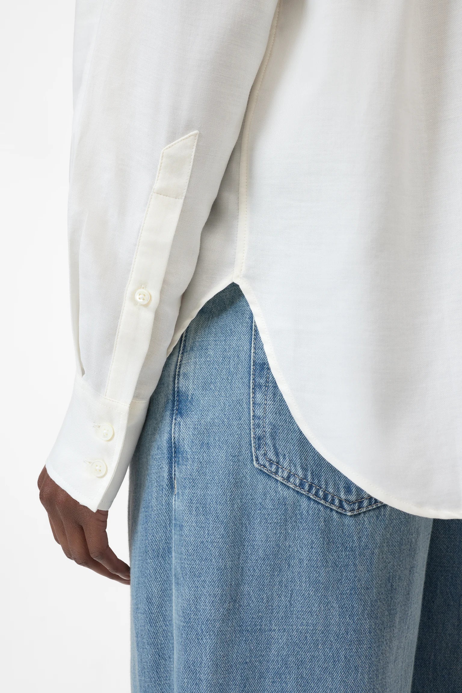close up view of buttons on the sleeve on the oversized button up in white