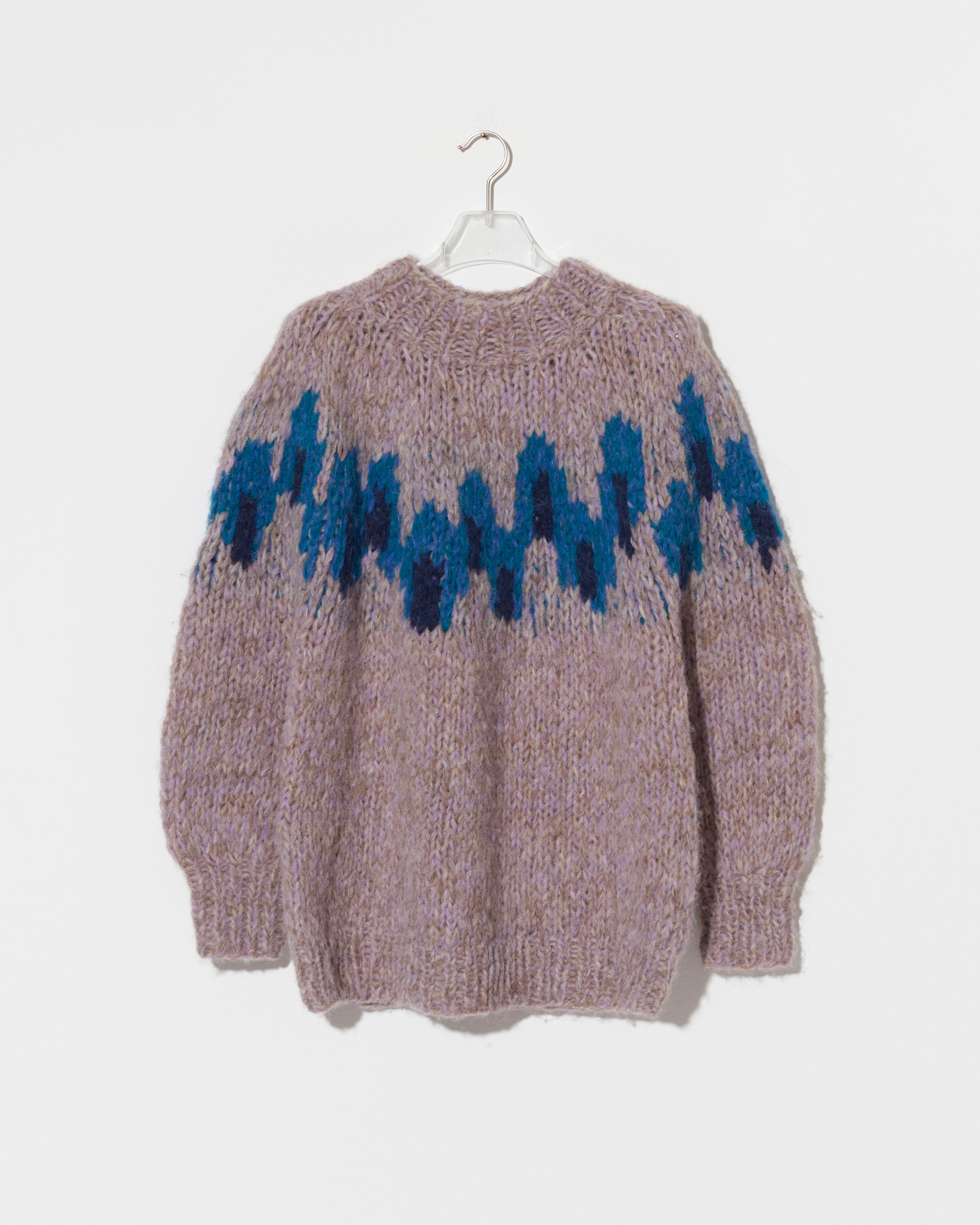 A chunky knit pullover sweater in a heathered dusty mauve-pink color, featuring a prominent blue and navy zigzag Fair Isle pattern across the chest, hanging on a white hanger against a light gray background.
