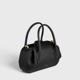 JONES + CO Oyster Mini Duffle in black pebble grained Italian leather with gold-tone hardware and top handles.