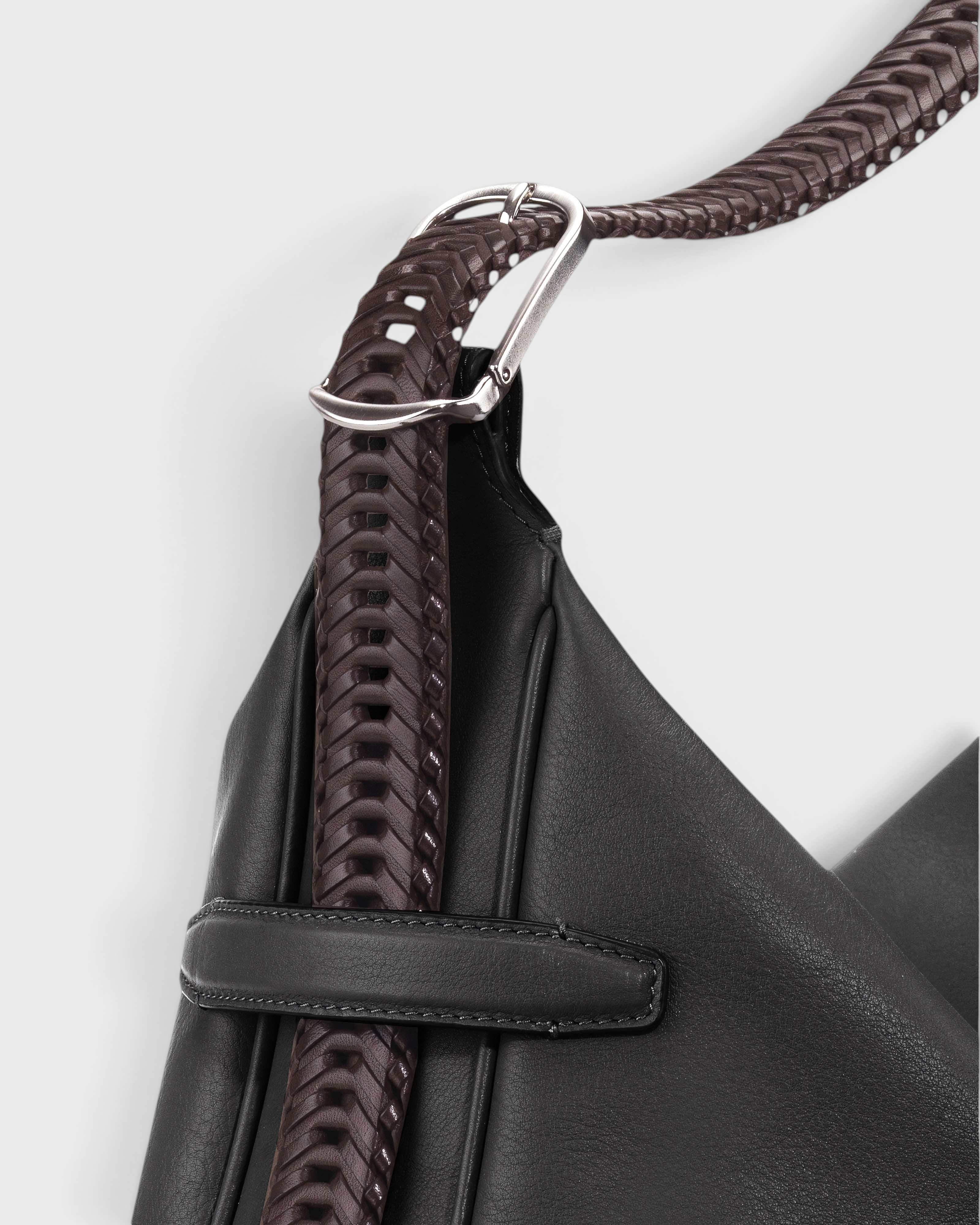 JONES + CO Rider M Elche black leather bag with a unique hand-braided dark brown strap and silver hardware detail.