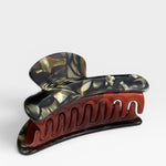 Marbled red and black hair clip on a white background