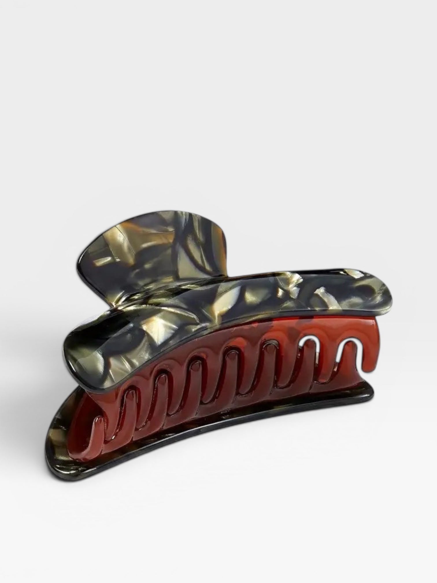 Marbled red and black hair clip on a white background