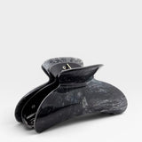 Black marble-patterned hair clip on a white background