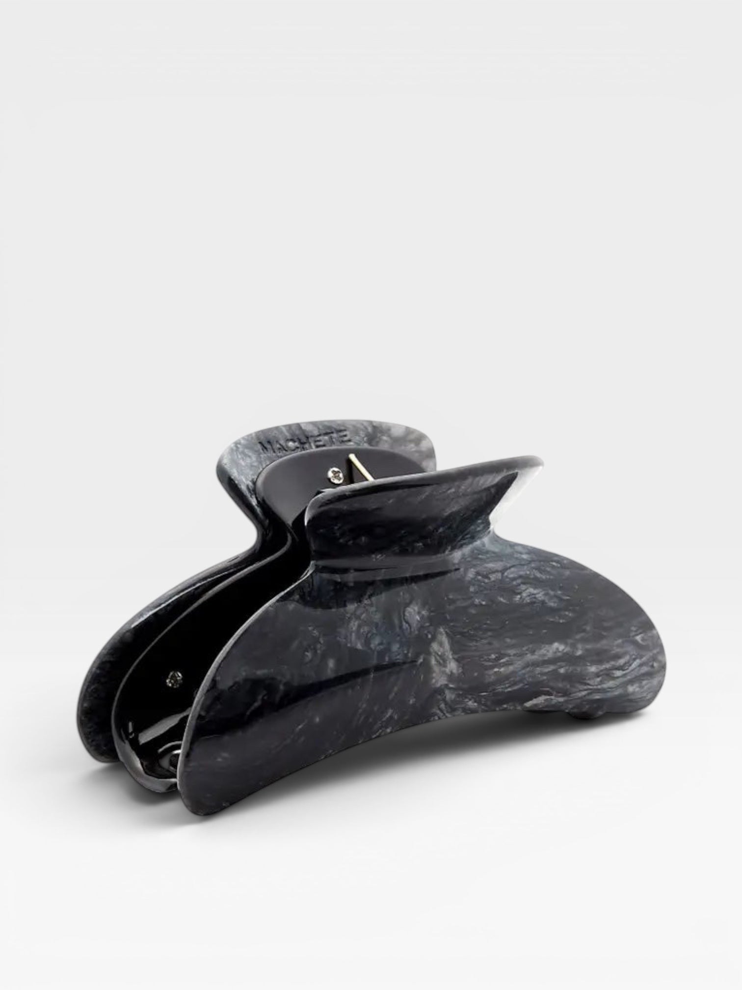 Black marble-patterned hair clip on a white background