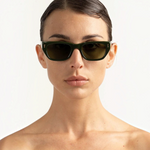 JONES + CO Parker cat-eye sunglasses in British Racing Green with gold hardware worn by a woman