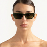 JONES + CO Parker cat-eye sunglasses in British Racing Green with gold hardware worn by a woman