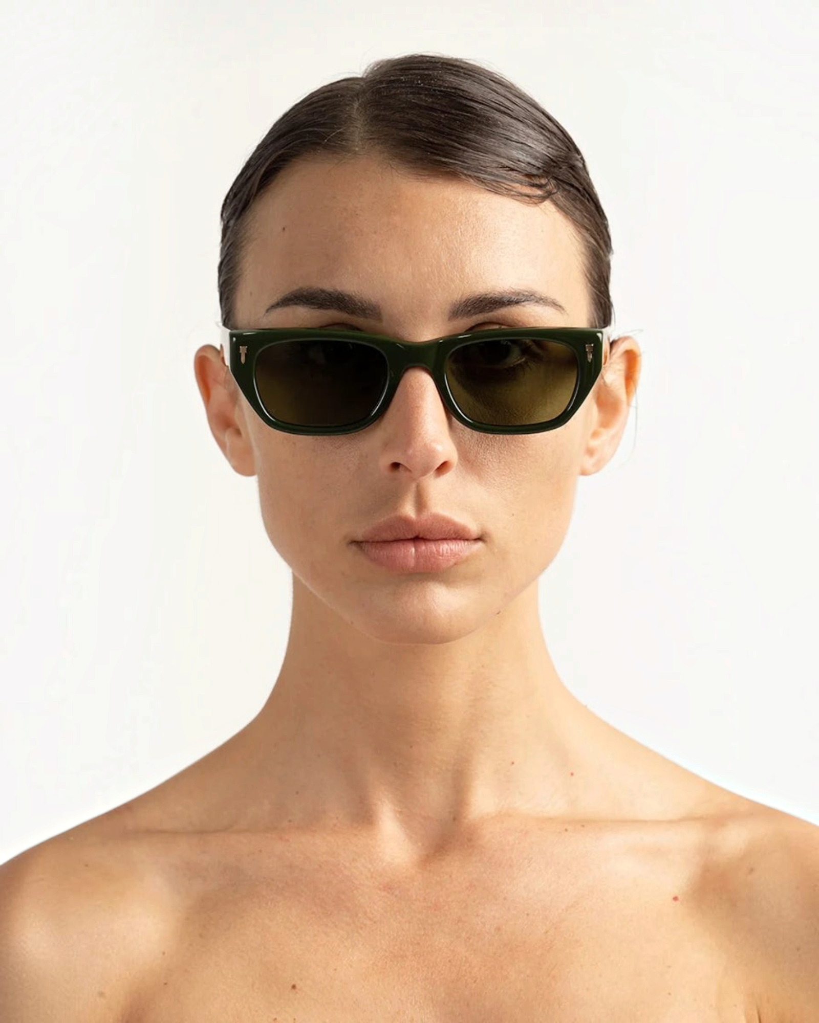 JONES + CO Parker cat-eye sunglasses in British Racing Green with gold hardware worn by a woman