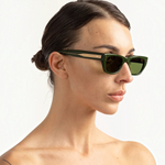 JONES + CO Parker cat-eye sunglasses in British Racing Green with gold hardware worn by a woman