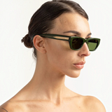 JONES + CO Parker cat-eye sunglasses in British Racing Green with gold hardware worn by a woman