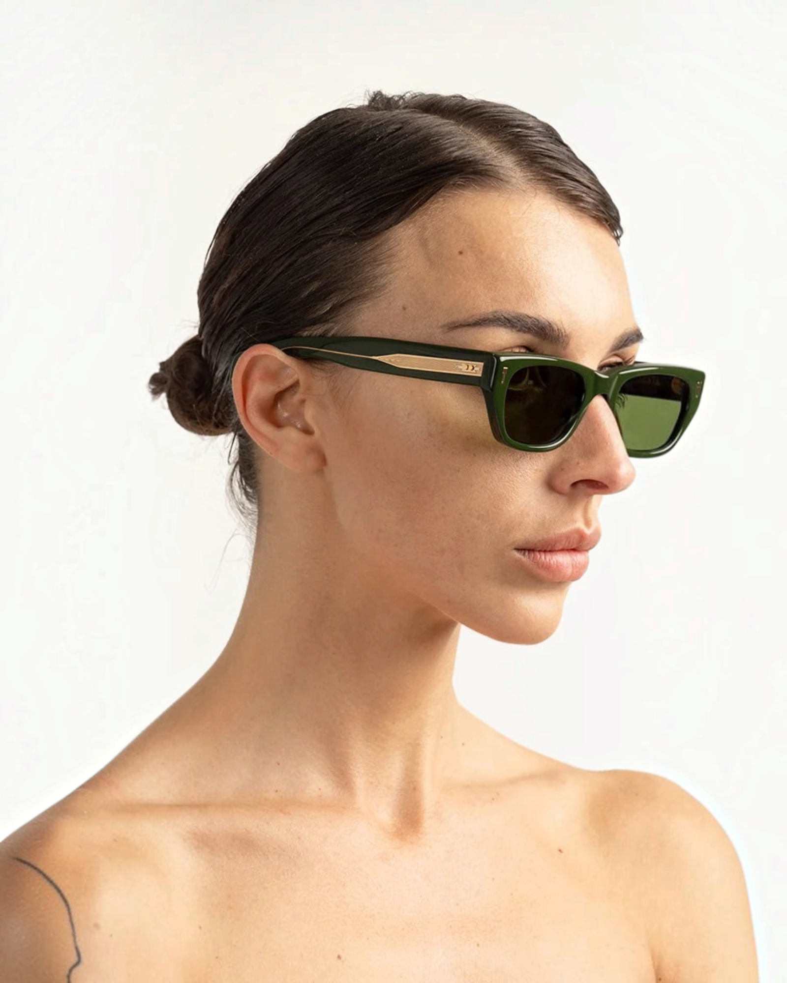 JONES + CO Parker cat-eye sunglasses in British Racing Green with gold hardware worn by a woman