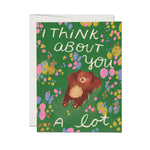 Greeting card with a bear illustration and floral design on a green background