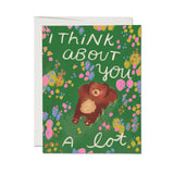 Greeting card with a bear illustration and floral design on a green background