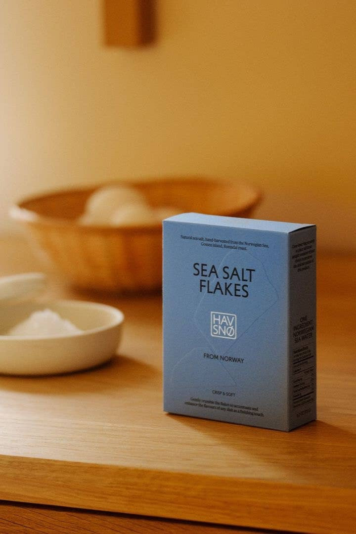 Box of havsno sea salt flakes on a wooden surface with a blurred background