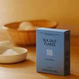 Box of havsno sea salt flakes on a wooden surface with a blurred background