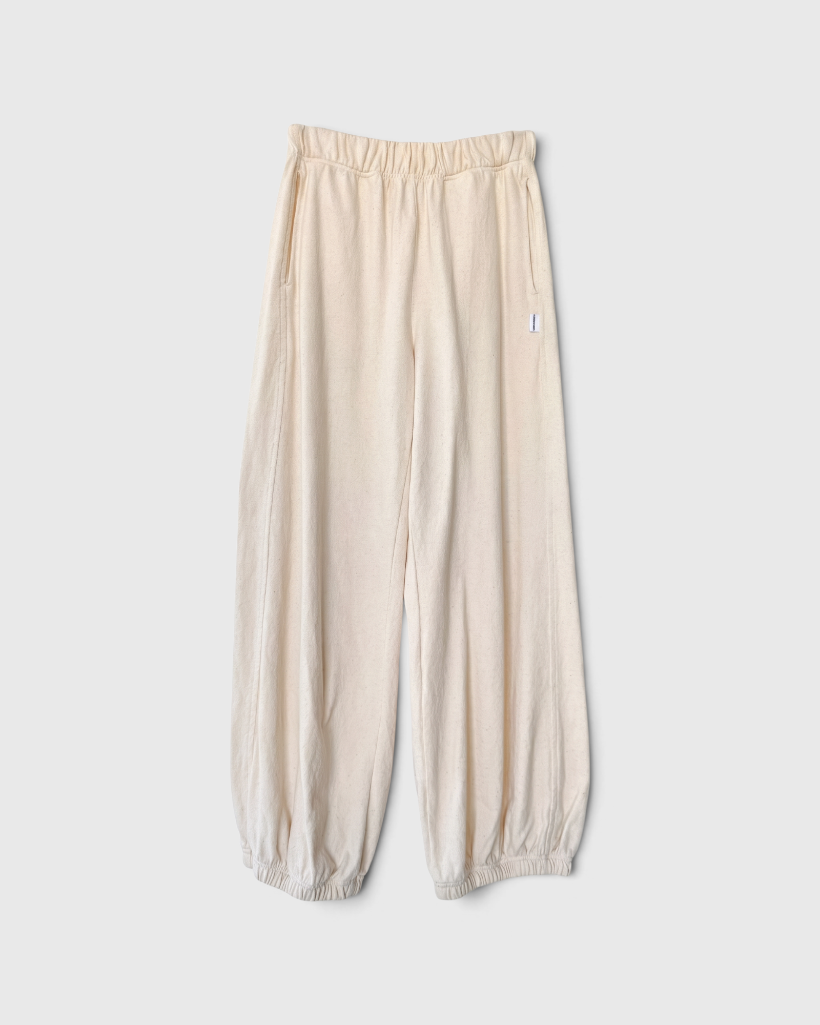 JONES + CO natural balloon pants with high elastic waist, side pockets, and gathered elastic leg openings.