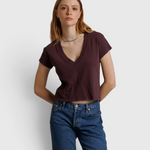 Model wearing a JONES + CO cherry lacquer recycled cotton V-neck cropped tee with blue jeans.