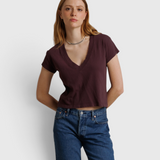 Model wearing a JONES + CO cherry lacquer recycled cotton V-neck cropped tee with blue jeans.