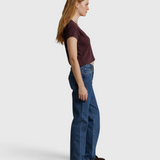 JONES + CO Alanis V Neck tee in cherry lacquer recycled cotton worn by a model with blue jeans, side profile view.