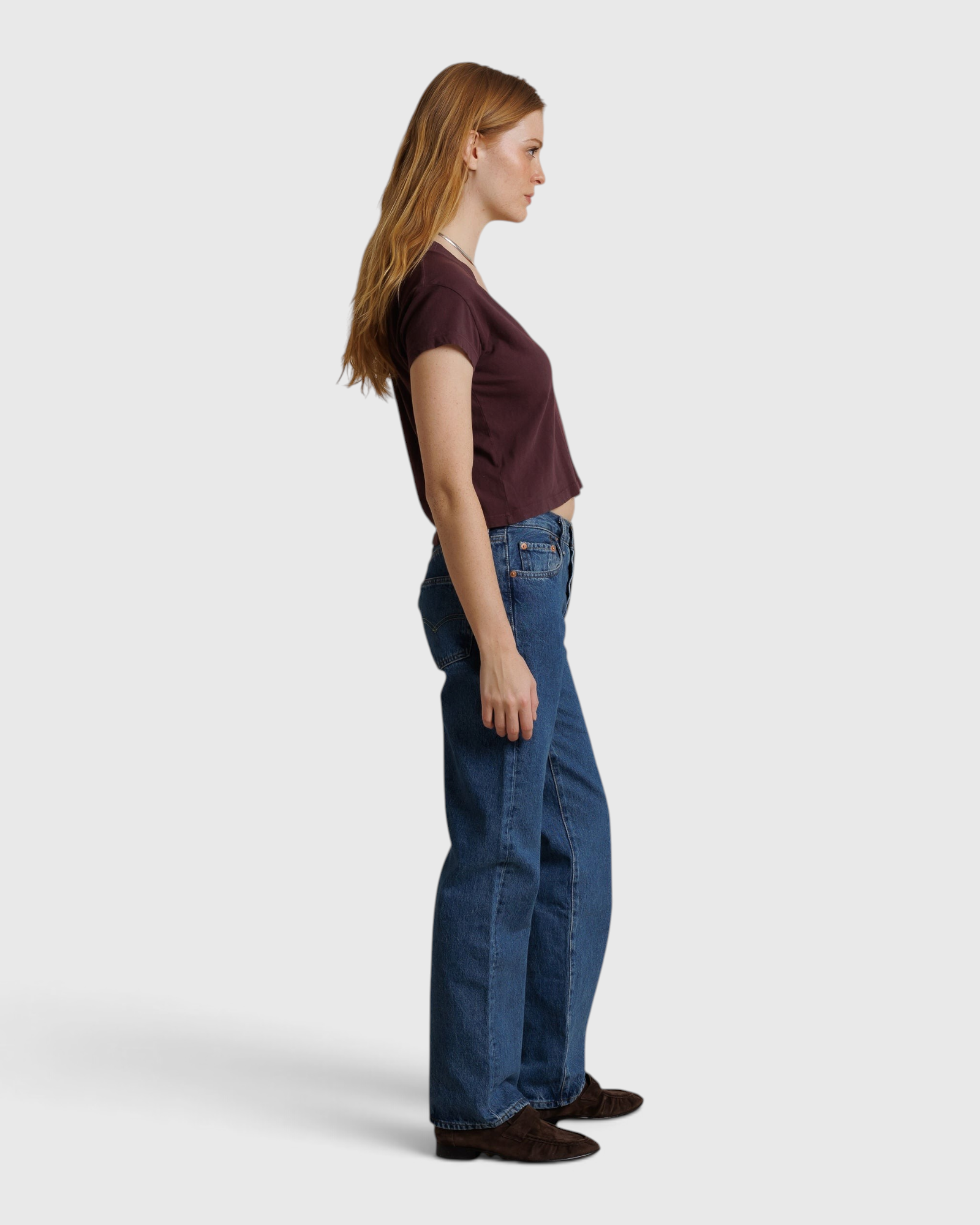 JONES + CO Alanis V Neck tee in cherry lacquer recycled cotton worn by a model with blue jeans, side profile view.