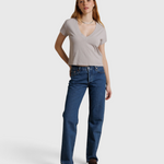 JONES + CO Alanis V-neck tee in cloud gray recycled cotton worn by a model with blue jeans against a neutral backdrop