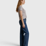 JONES + CO Alanis V-neck tee in cloud gray recycled cotton worn with blue jeans by a model in profile view