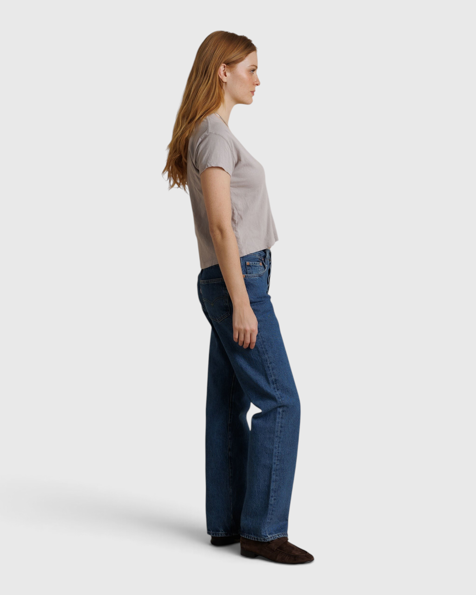JONES + CO Alanis V-neck tee in cloud gray recycled cotton worn with blue jeans by a model in profile view