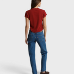 Back view of a woman wearing a JONES + CO ruby red recycled cotton V-neck t-shirt paired with blue jeans.