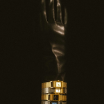 Gold ring with black accents on a reflective black surface