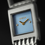 Breguet watch with blue face and gold hands on a black background