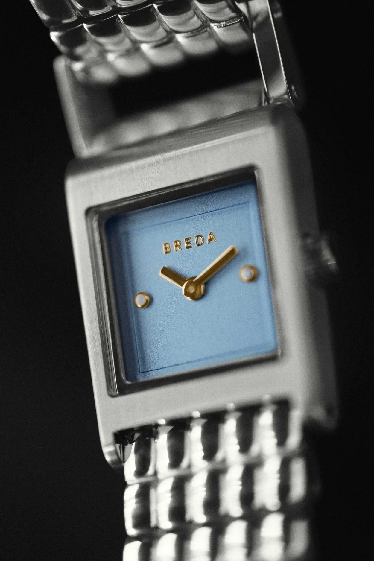 Breguet watch with blue face and gold hands on a black background