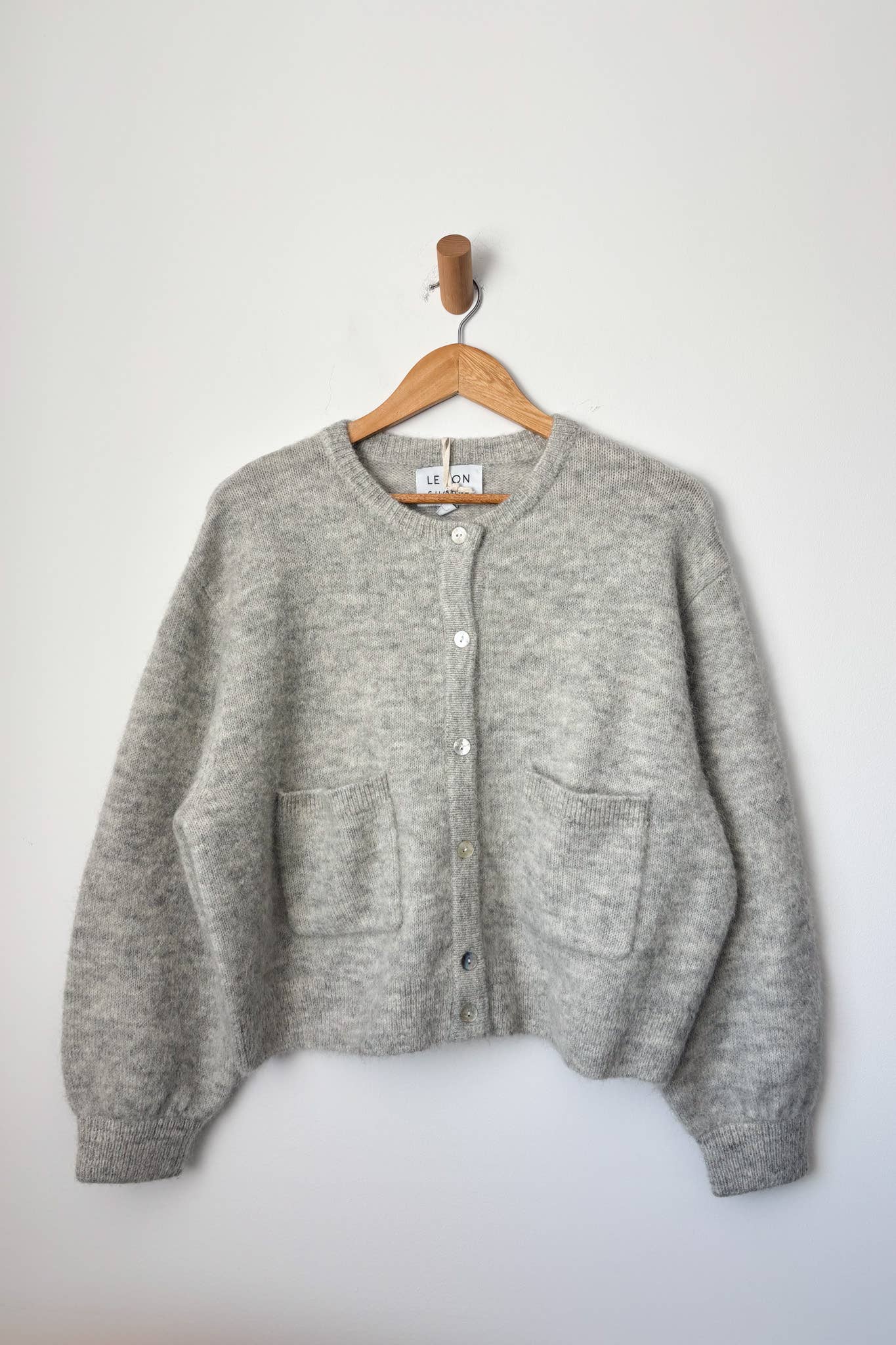 Amélie Alpaca Cardigan - Light Grey hanging on hanger