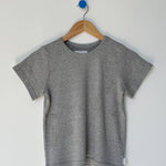 Gray t-shirt on a wooden hanger against a white background
