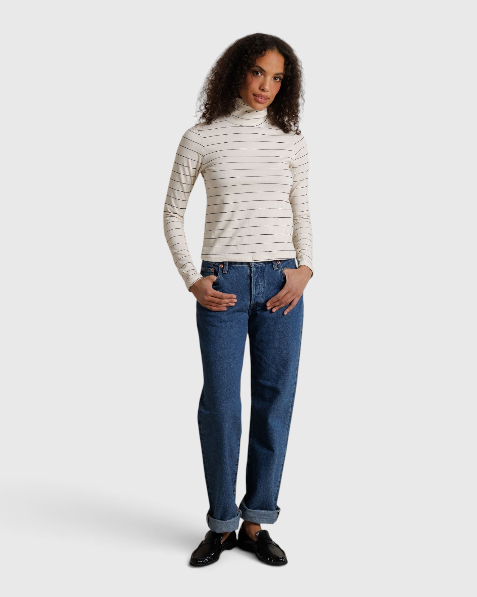 JONES + CO Cindy long sleeve turtleneck top in natural stripe worn with blue jeans by a model