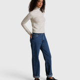Model wearing JONES + CO Cindy long sleeve turtleneck in natural stripe with blue jeans and black loafers
