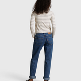 JONES + CO Cindy long sleeve turtleneck in natural stripe worn with blue cuffed jeans and black loafers, back view
