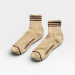 Pair of beige socks with brown stripes and 'Le Bon Shoppe' branding on a white background