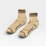 Pair of beige socks with brown stripes and 'Le Bon Shoppe' branding on a white background