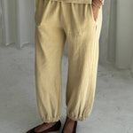 Person wearing yellow pants and a matching top on a plain background