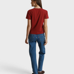 Model wearing a JONES + CO ruby red boxy short sleeve cotton Harley tee, viewed from the back with blue jeans.