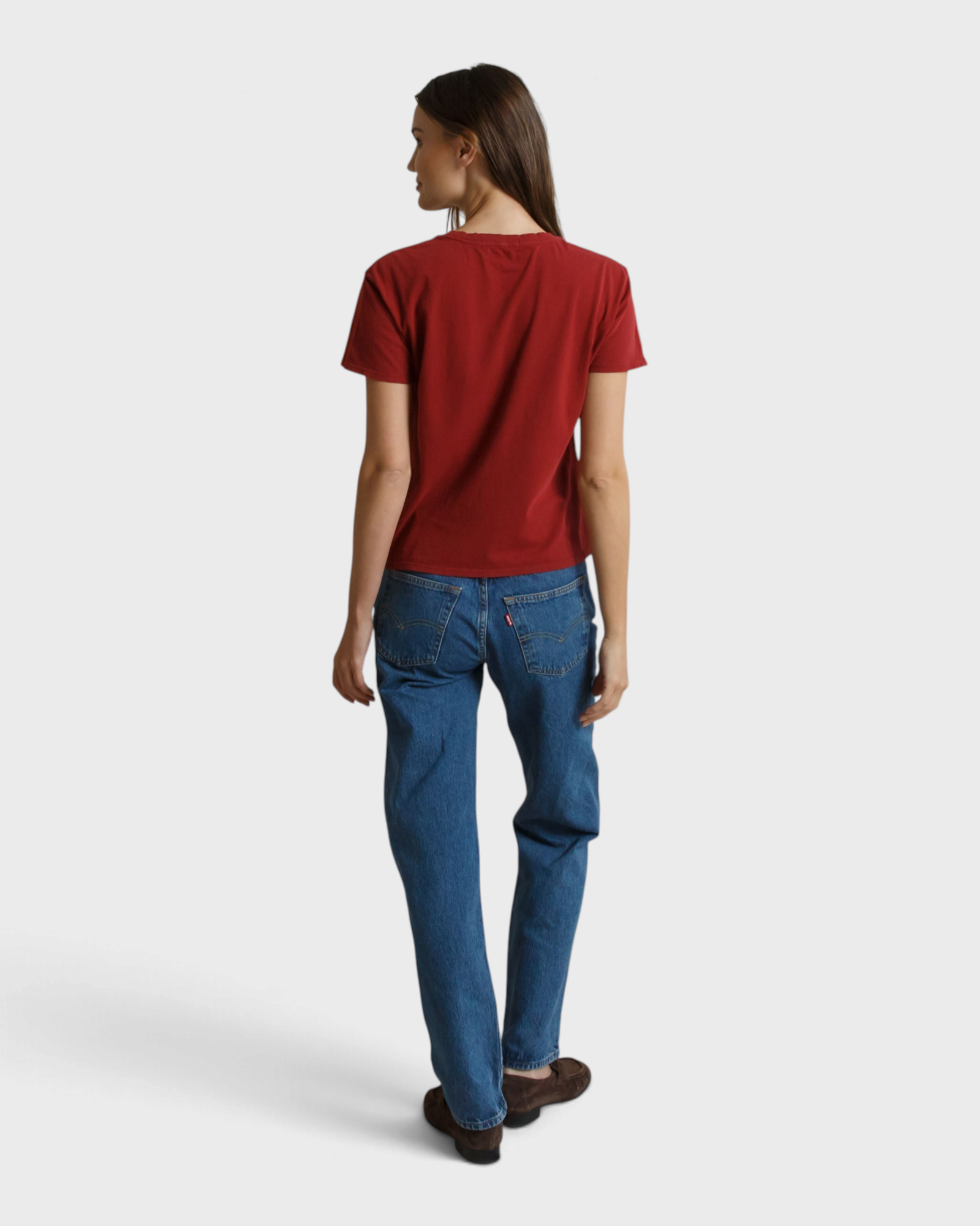 Model wearing a JONES + CO ruby red boxy short sleeve cotton Harley tee, viewed from the back with blue jeans.