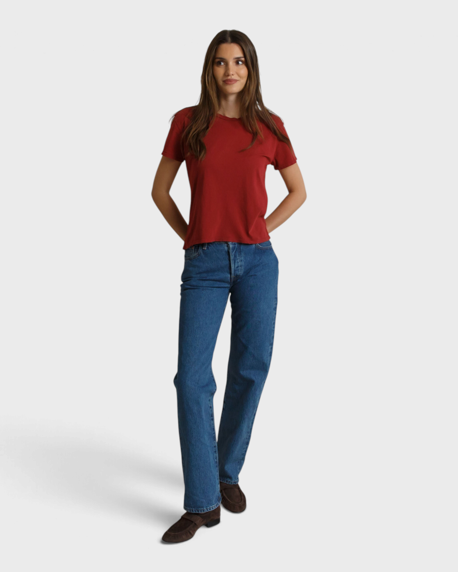 Model wearing a JONES + CO ruby red boxy cotton crew neck t-shirt with blue jeans and brown loafers