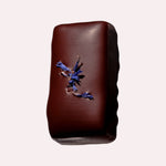 JONES + CO dark chocolate bar with almond caramel, tamari almonds, astragalus, and blue cornflower garnish.
