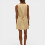 JONES + CO Alondra mini dress in daffodil yellow with a scalloped hem and tie-back detail on a model.
