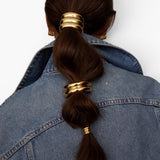 JONES + CO Anya Mini Pony Cuff in gold worn on a brunette ponytail with a denim jacket.