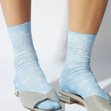 JONES + CO light blue Bahia socks with metallic paisley bandana pattern worn with grey open-toe shoes