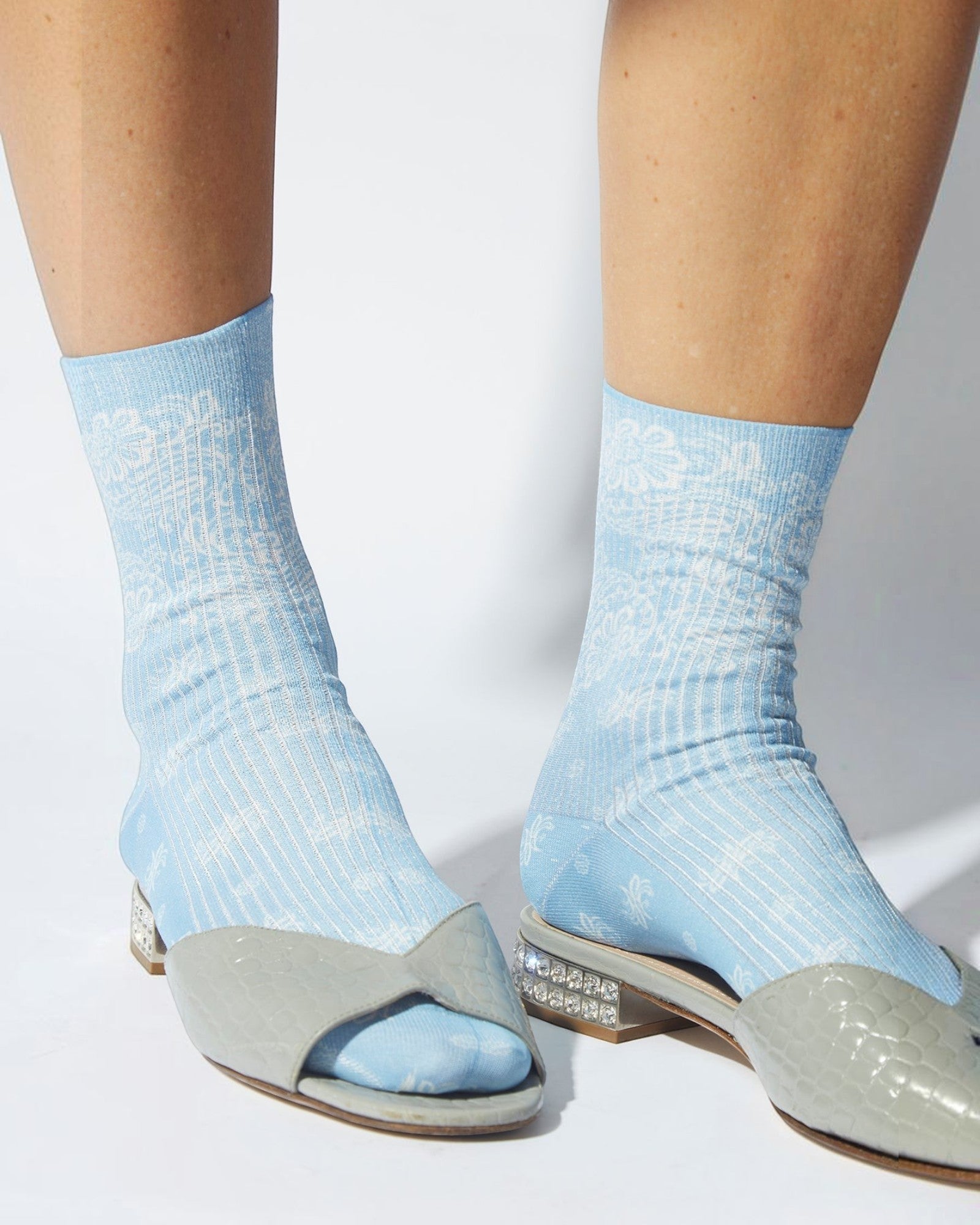 JONES + CO light blue Bahia socks with metallic paisley bandana pattern worn with grey open-toe shoes