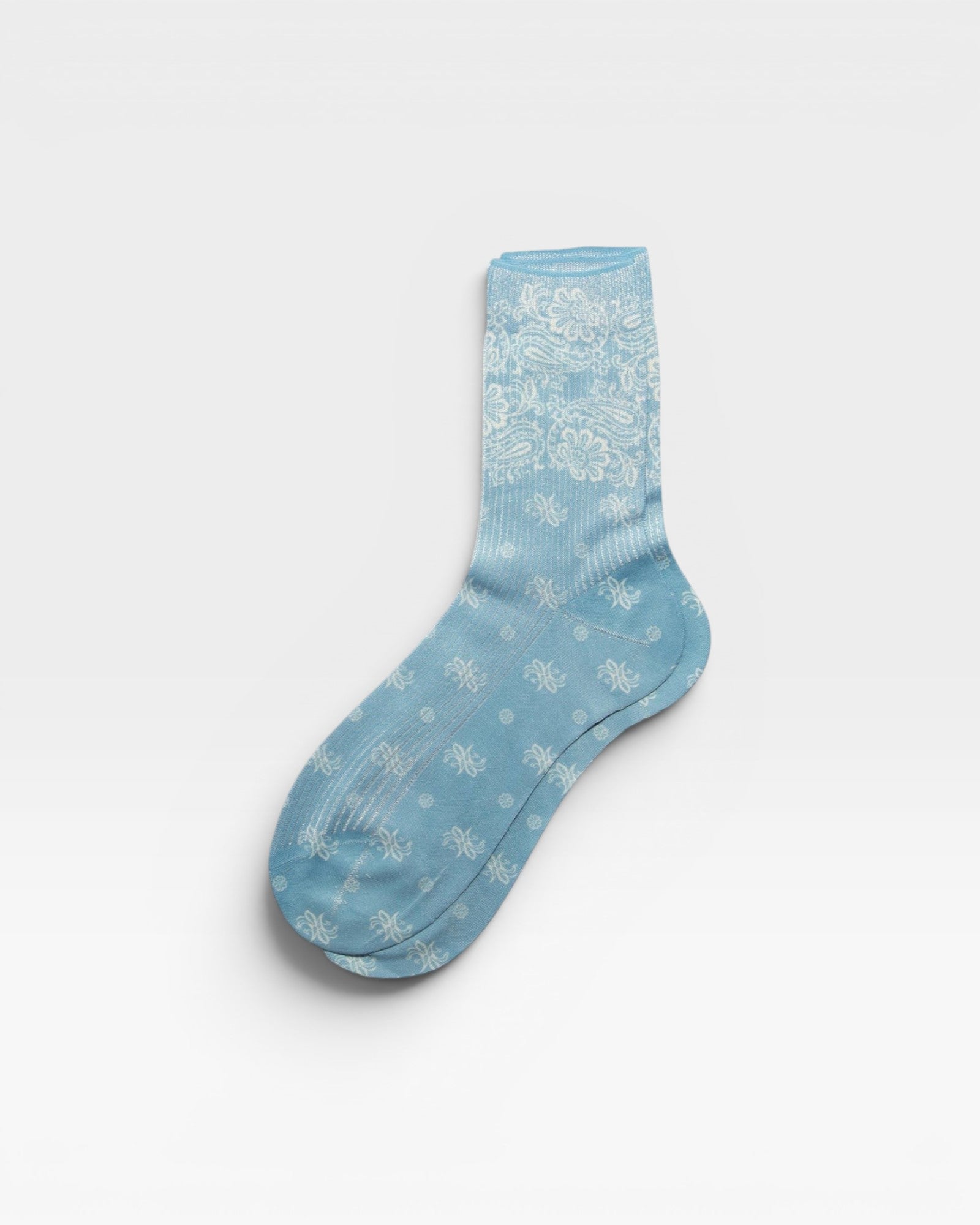 JONES + CO light blue Bahia socks with a white paisley bandana pattern and a subtle metallic finish.
