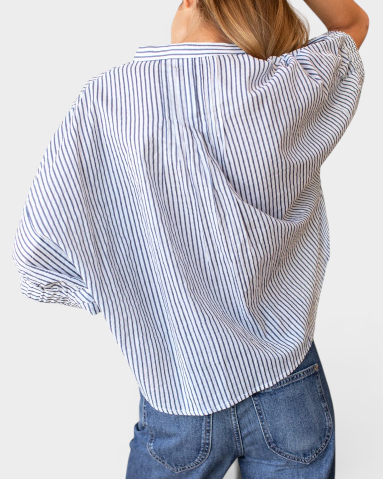 JONES + CO organic cotton blue indigo striped shirt with mandarin collar and batwing sleeves on a model.